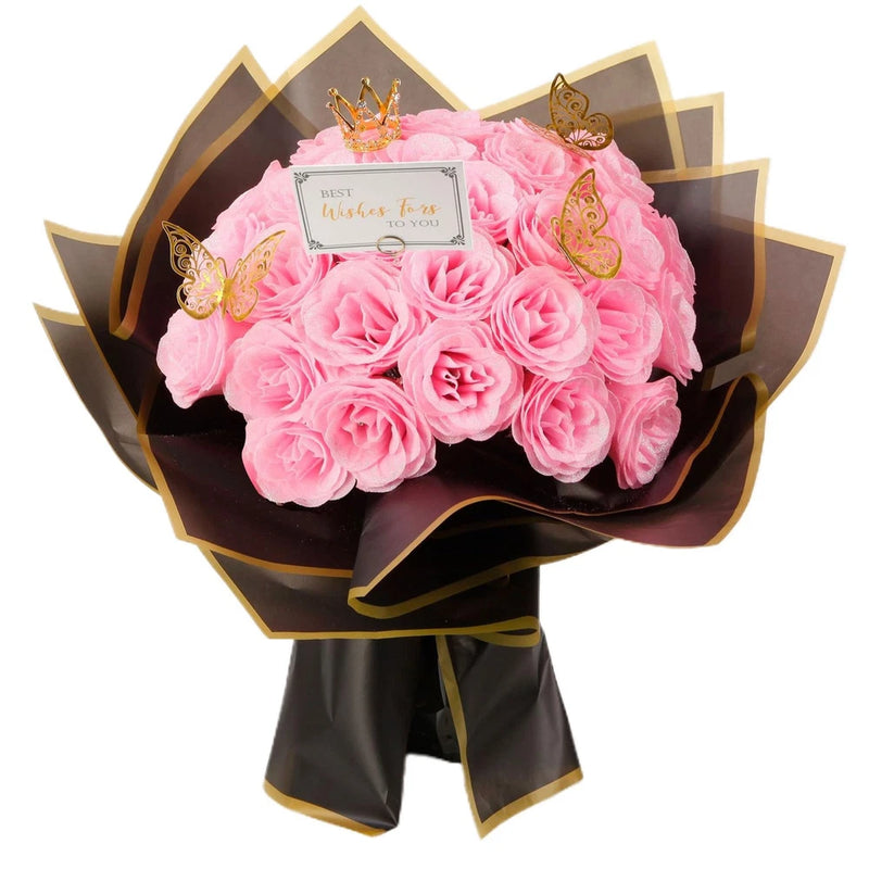 Pink faux rose bouquet with layered petals, wrapped with black and gold ribbon
