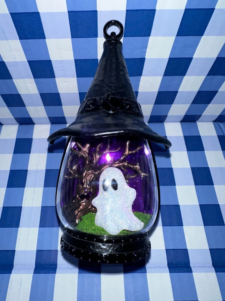 Black plug-in fragrance warmer with glass chimney and purple-lit ghost insert
