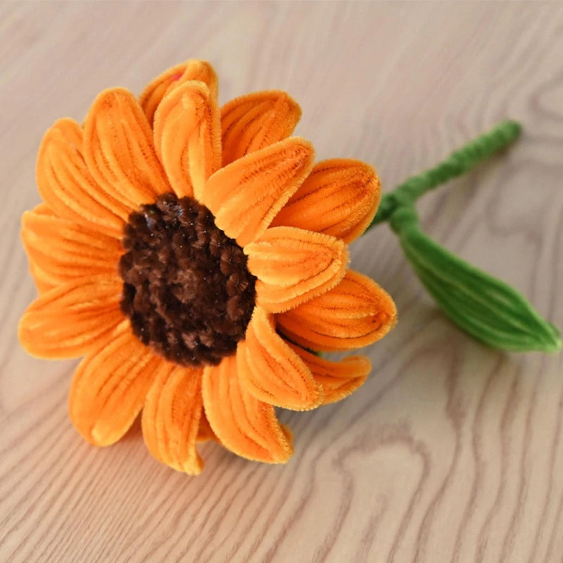 Artificial sunflower with orange petals and dark center, green stem and leaf