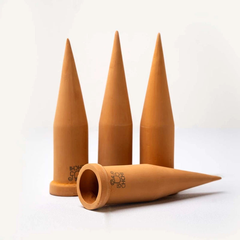 Terracotta self-watering garden spikes, 3 upright with one laid down, clay tips