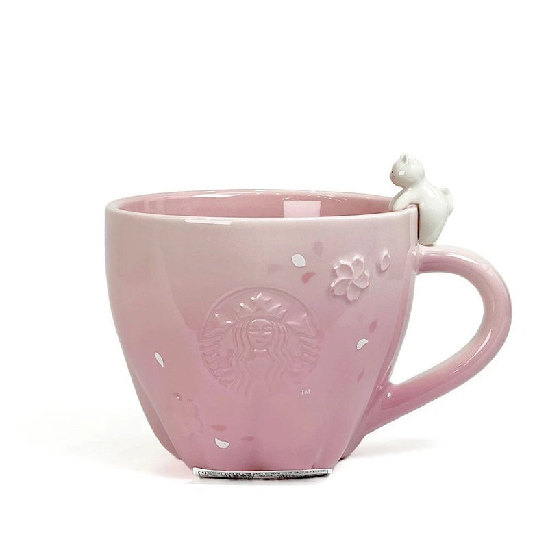 Pink ceramic Starbucks mug with embossed cherry blossom flowers and small topper