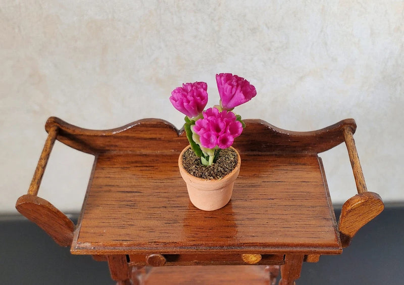 Miniature magenta carnation flowers in terracotta planter, dollhouse scale
