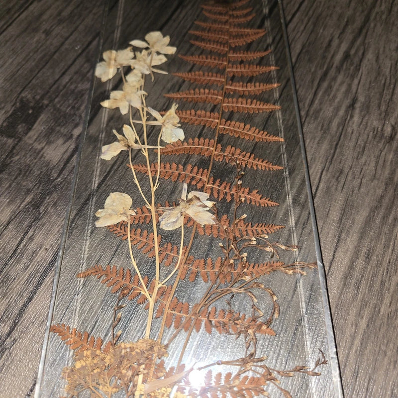 Pressed fern and pale dried flowers in clear stained-glass panel