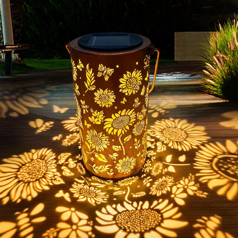 Sunflower solar lantern, cylindrical metal with cutout floral pattern, warm glow