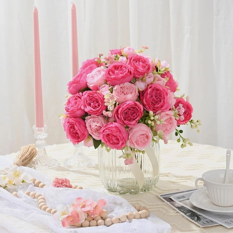 Artificial pink peony flower bouquet with many blooms in clear glass vase