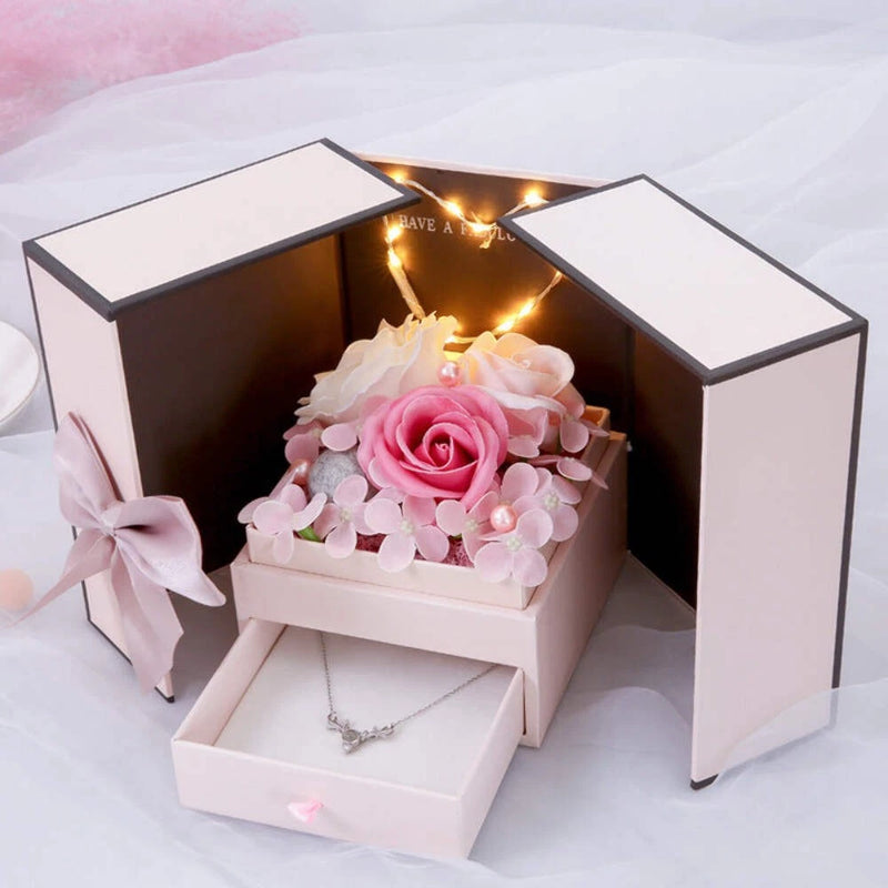 White double-door jewelry box with rose flower decor and warm string lights