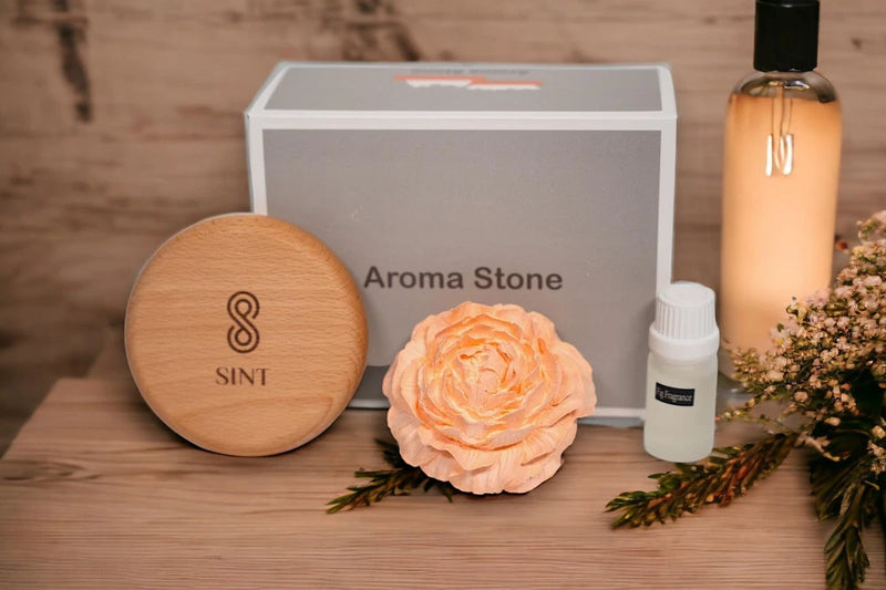Round wooden aroma stone diffuser with SINT logo, peony flower and essential oil bottle