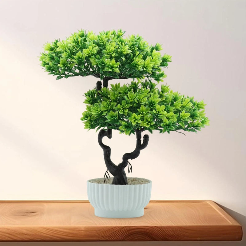 Artificial bonsai tree with green foliage in a light blue ribbed ceramic pot