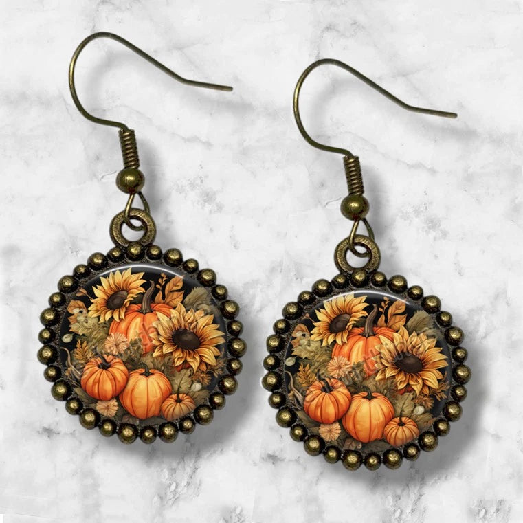 Bronze dangle earrings with oval pumpkin and sunflower floral artwork in beaded frame
