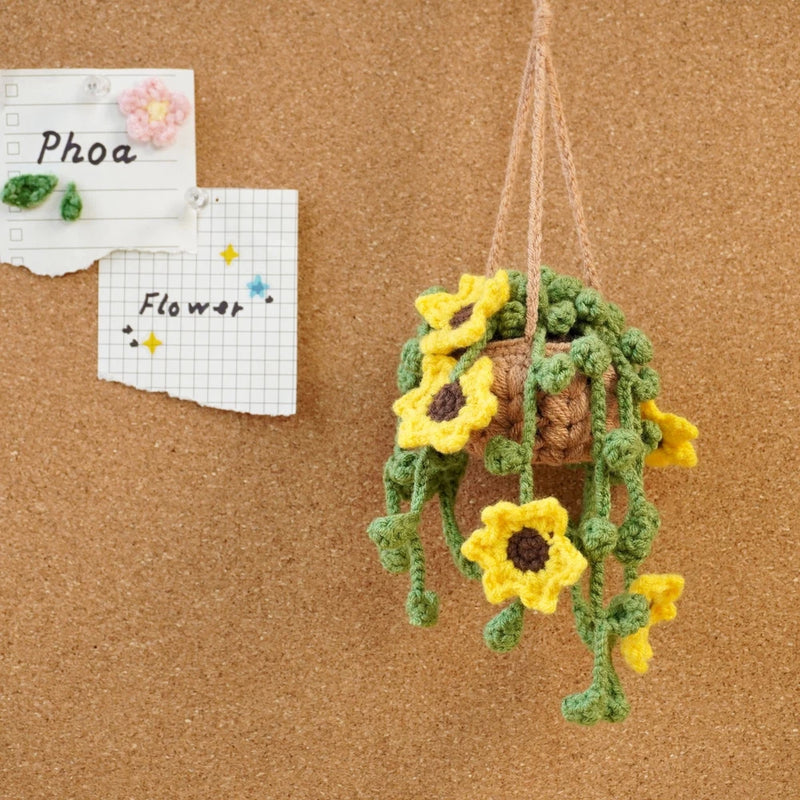 Crochet hanging basket decor with brown basket, green leaves, and yellow sunflower blooms