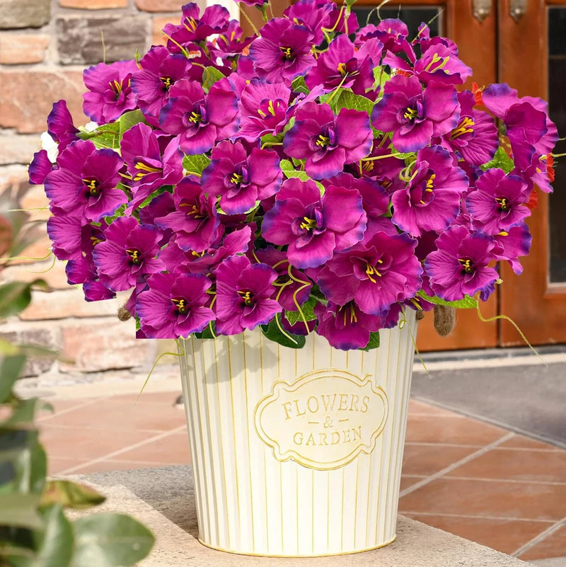 Artificial purple hibiscus flowers with yellow centers in striped garden pot