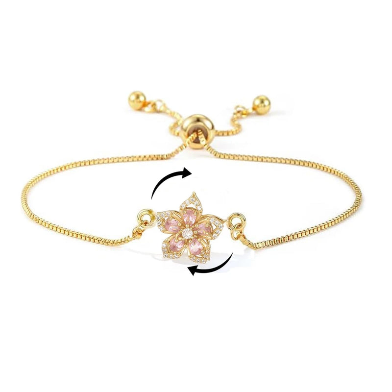 Gold chain link bracelet with pink flower centerpiece and rotating fidget arrow accents