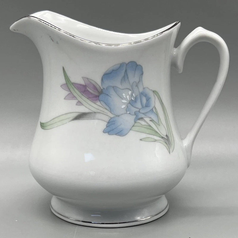 Porcelain creamer pitcher with blue floral design and platinum trim