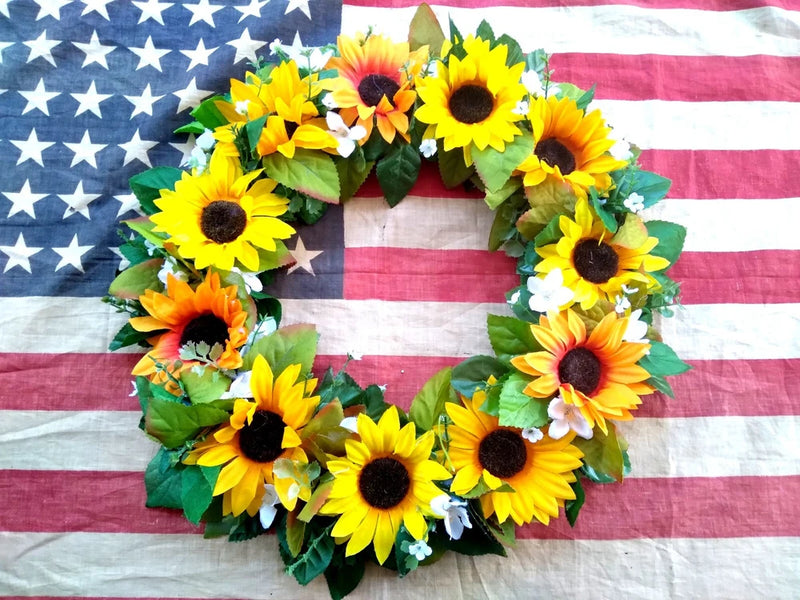 Silk sunflower floral wreath with yellow and orange blooms and green leaves