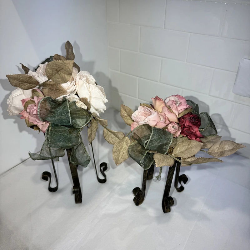 Faux flower bouquet with pink blooms, green fabric ribbon, and black iron legs stands