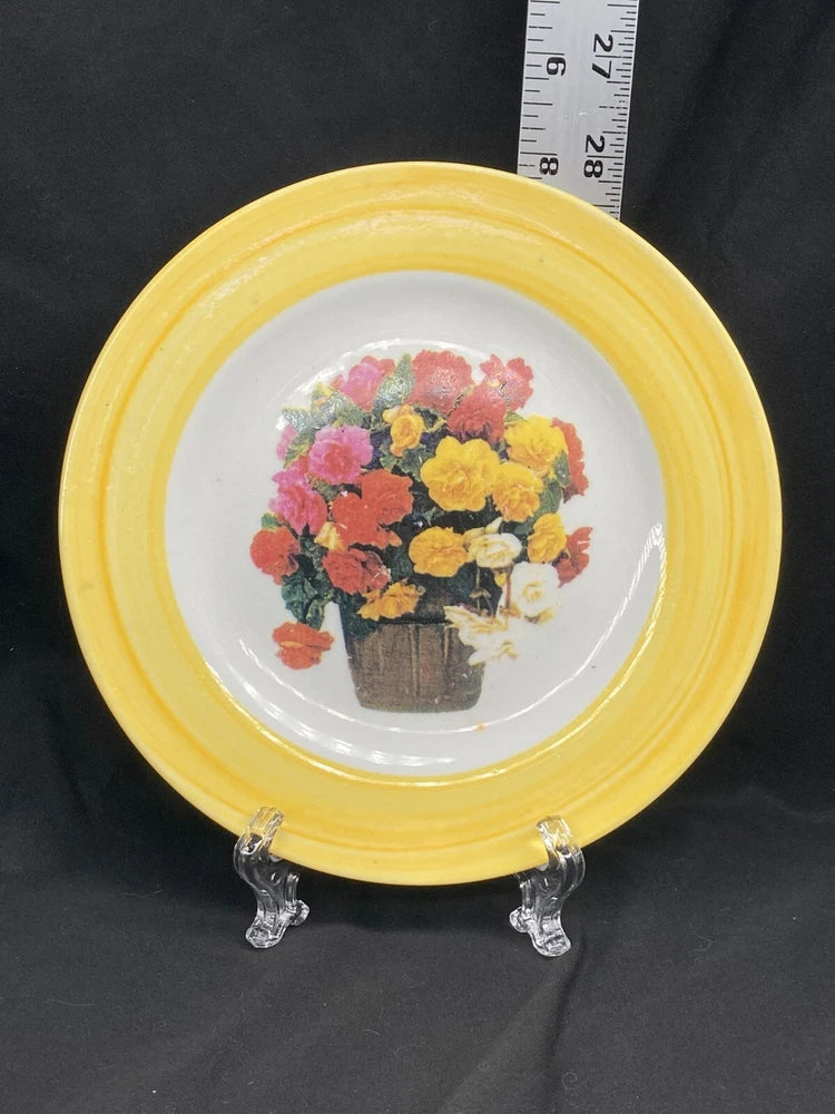 Decorative collector plate with yellow rim and bouquet of pink, coral, and yellow carnations