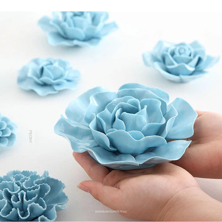 Light blue peony 3D ceramic flower wall decor with layered petals, held by hand
