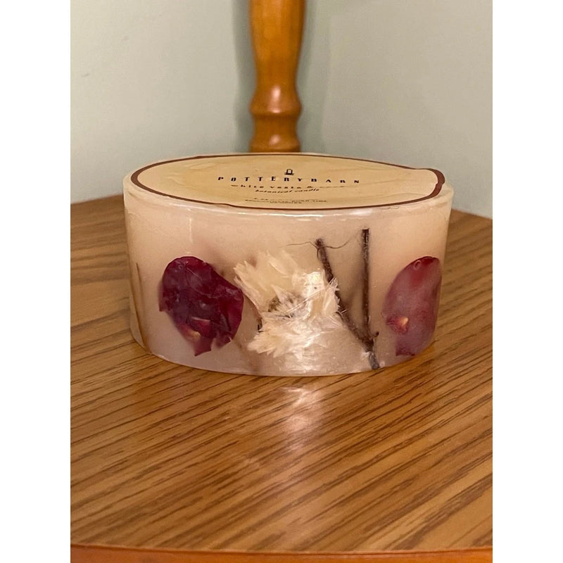 Pottery Barn dried flower pillar candle in off-white wax with red rose petals, glass jar lid