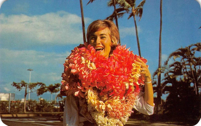 Vintage flower lei postcard: woman smiling in red and yellow carnation-style lei.