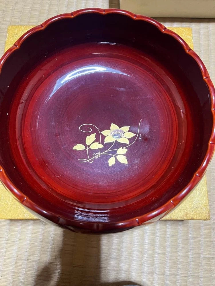 Red decorative pot with wavy rim, gold trim, and small flower illustration on top