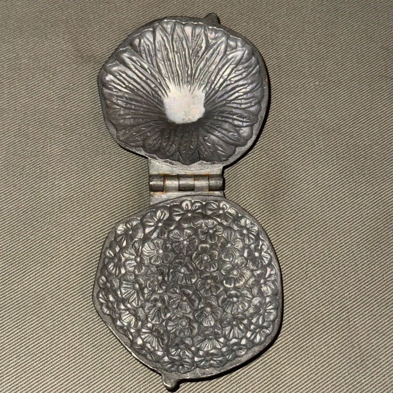 Pewter flower toy candy mold with two round halves and embossed floral pattern