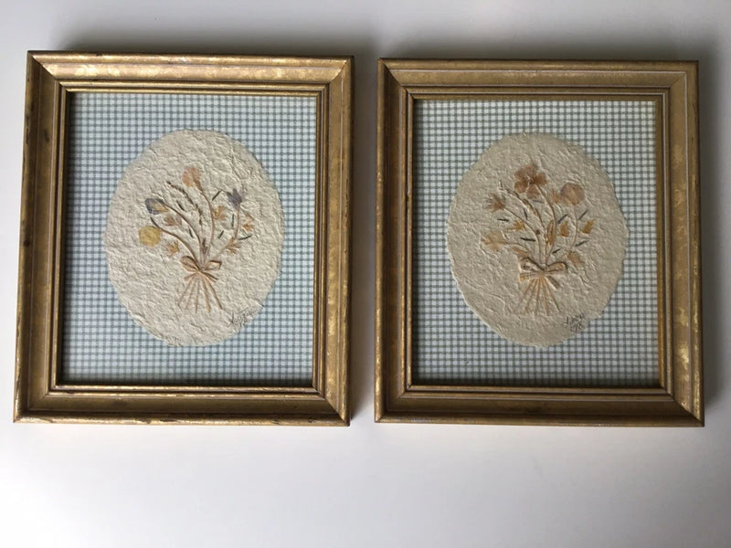 Pair of framed wall art prints with pressed flower ovals and gold-toned frames