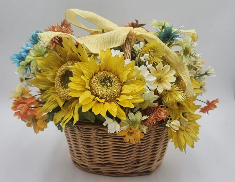Vintage flower basket with artificial sunflowers and mixed yellow, white, blue blooms