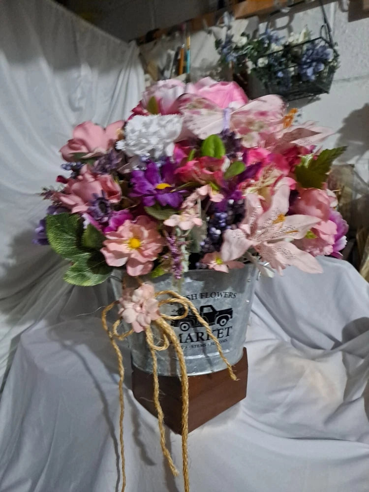 Country-style flower arrangement in gift box with pink and purple blooms and ribbon bow