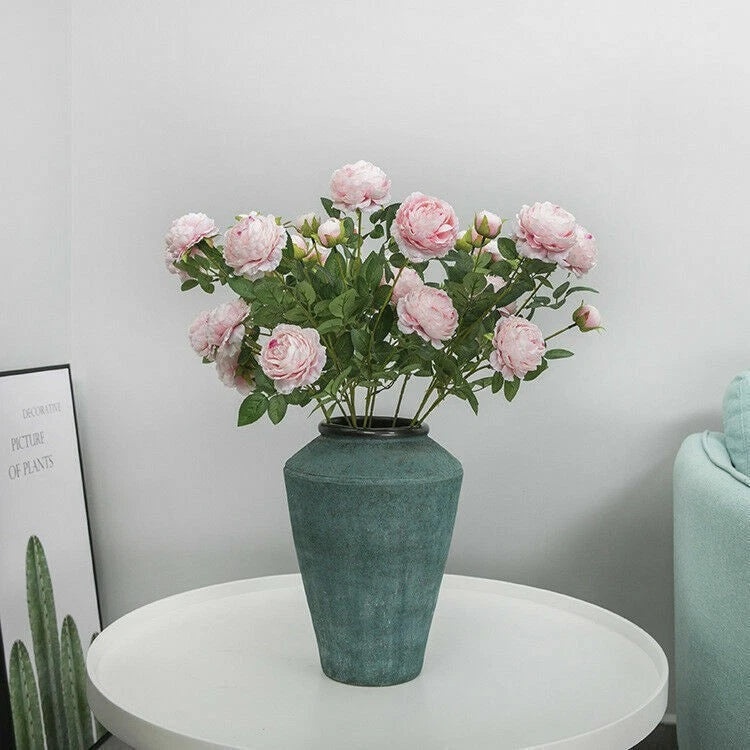 Pink silk peony wedding bouquet with pink blooms on leafy stems, arranged in dark green vase