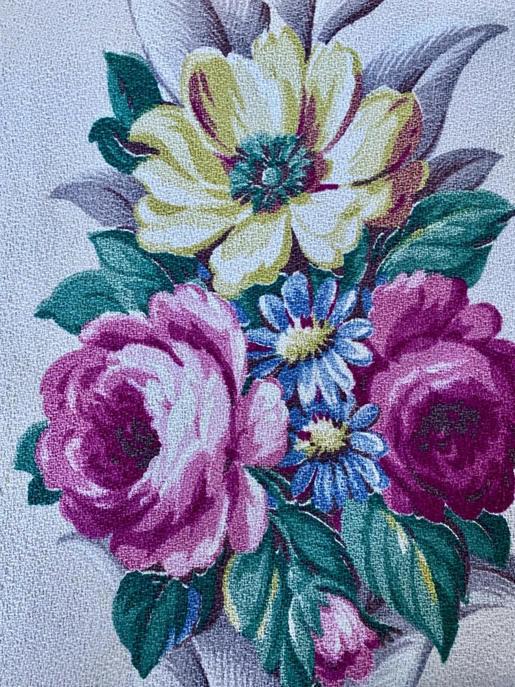 Vintage floral fabric with pink, purple and yellow roses and green leaves
