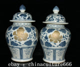 Pair of blue and white porcelain lidded jars with gilt peony medallions and ornate scrollwork