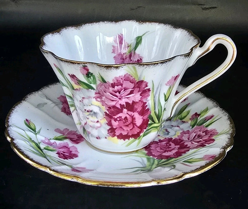 Fluted pink floral teacup with saucer, gold-trim rim and handle.