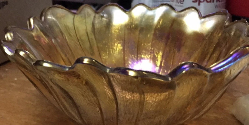 Iridescent carnival glass ruffle bowl with amber-gold tones, scalloped rim