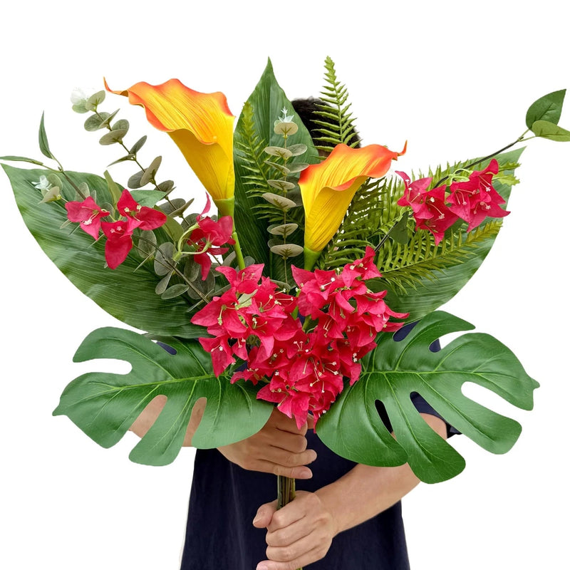 Artificial tropical bouquet with orange calla lilies, pink flowers, and green monstera leaves