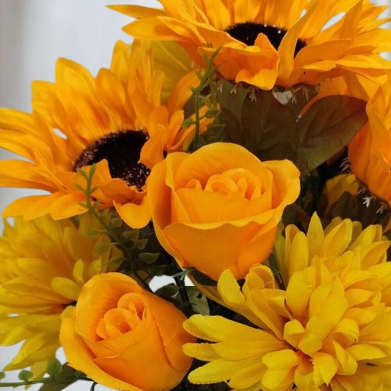 Artificial yellow sunflower and rose floral bush with orange blooms and green leaves