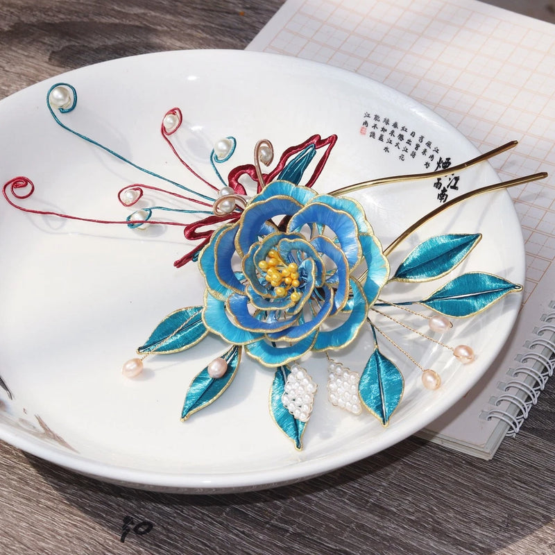 Embroidered peony hair crown with blue flower, teal leaves, pearls, and two gold hairpins