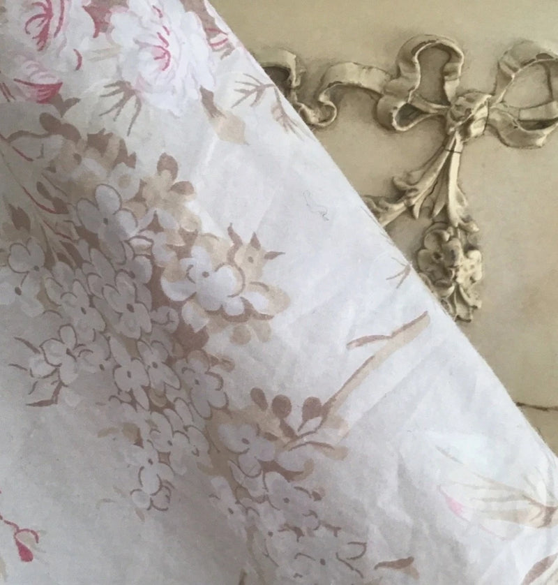 White floral fabric with pink rose and leaf print, soft woven texture
