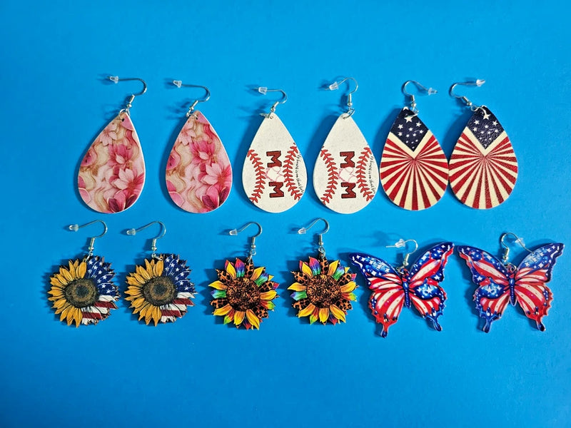 Set of six pairs of drop earrings with floral, sunflower, and butterfly designs, blue hooks