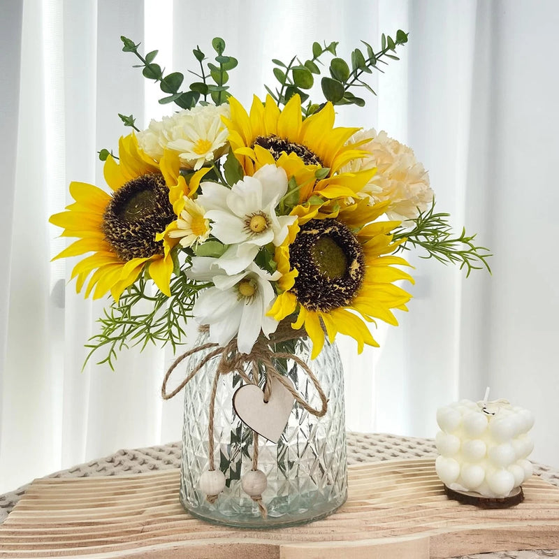 Artificial sunflower and daisy bouquet with greenery in a clear glass vase