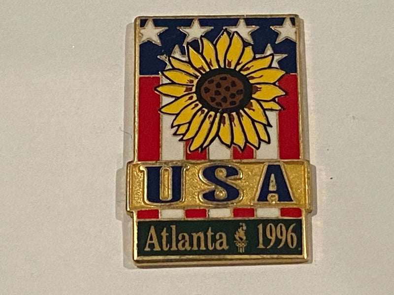 Gold lapel pin with sunflower, U.S. flag stripes, Atlanta 1996 and stars