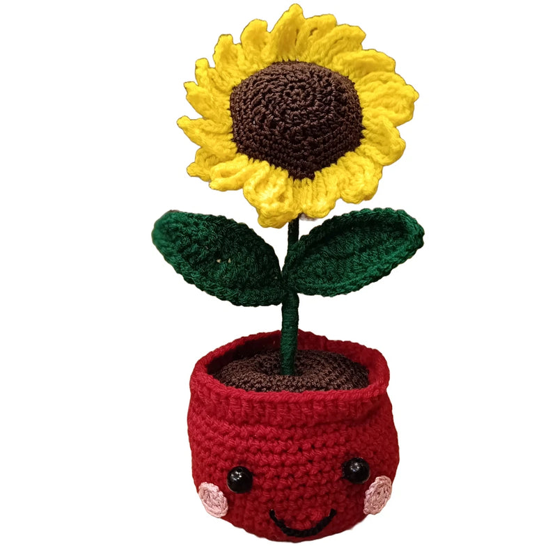 Crocheted sunflower with yellow petals in red smiling pot with green leaves