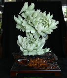 Light green carved jade peony and bird sculpture on dark ornate wood base