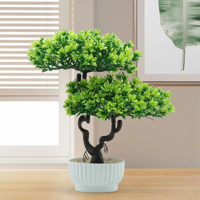 Small faux bonsai tree with bright green foliage, black trunk, in light blue ribbed pot