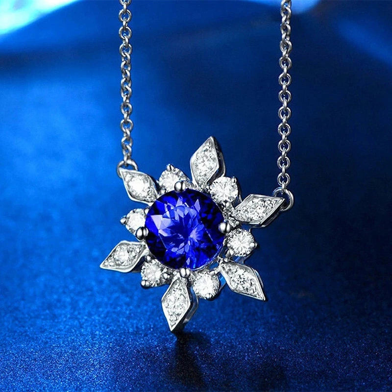 Silver sunflower pendant necklace with blue round center stone and clear diamond-like petals