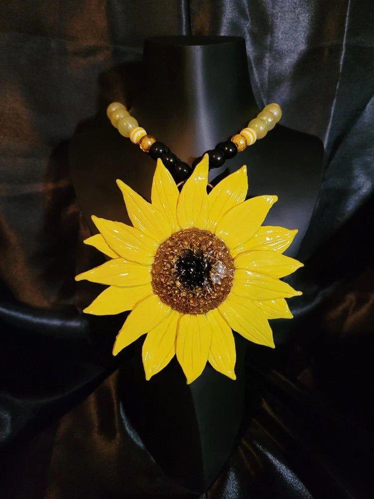 Sunflower statement necklace with yellow pendant and black-and-gold bead strand
