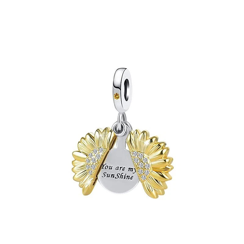 Sterling silver dangle charm with yellow sunflower petals and heart-shaped clear crystal center