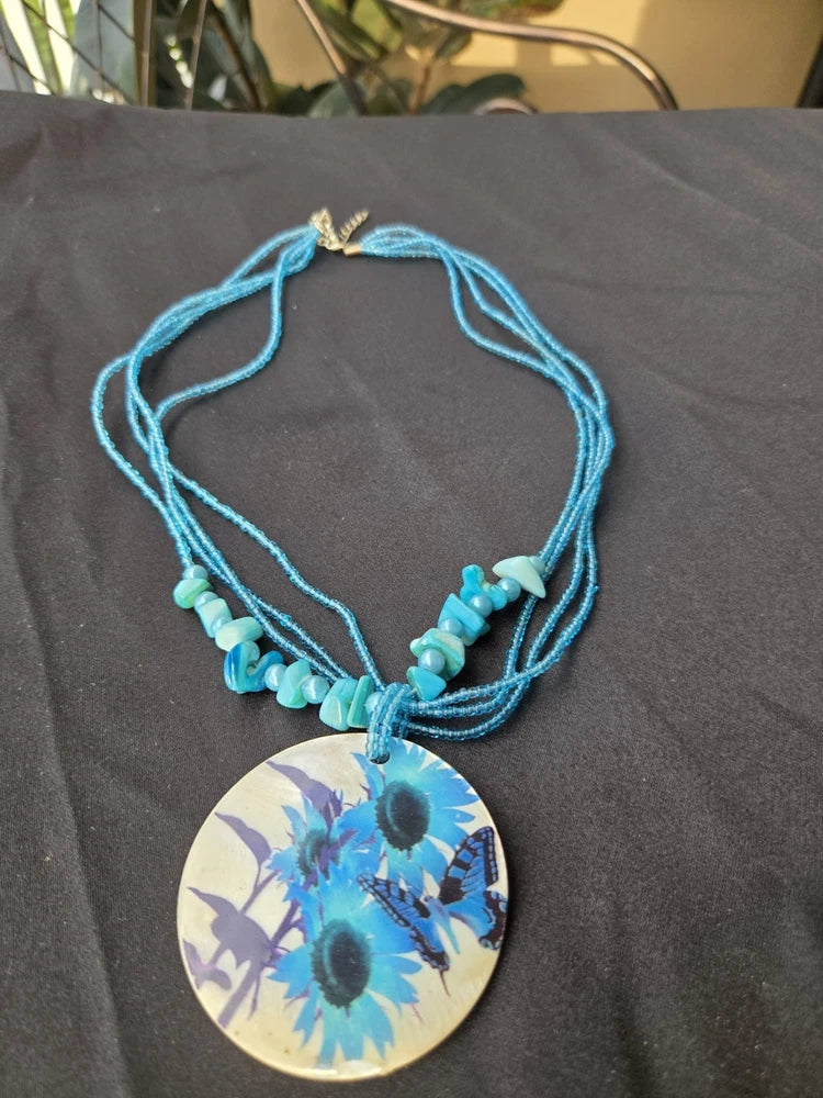 Boho blue beaded necklace with round sunflower butterfly pendant