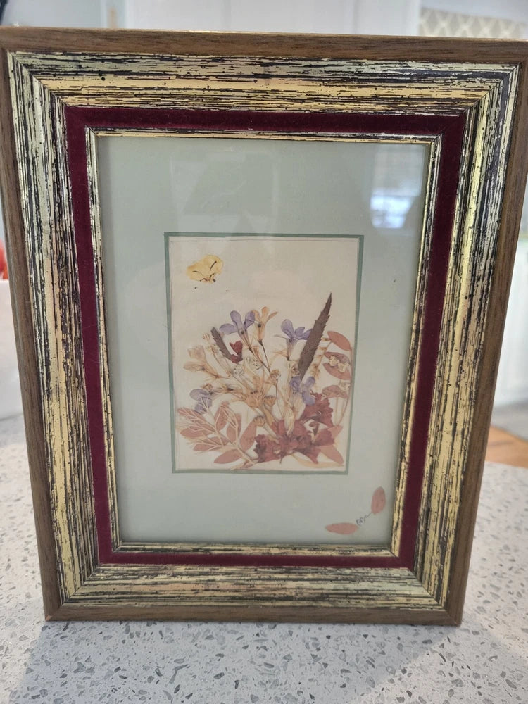 Distressed wood framed pressed wildflower arrangement with pastel blossoms in a white mat