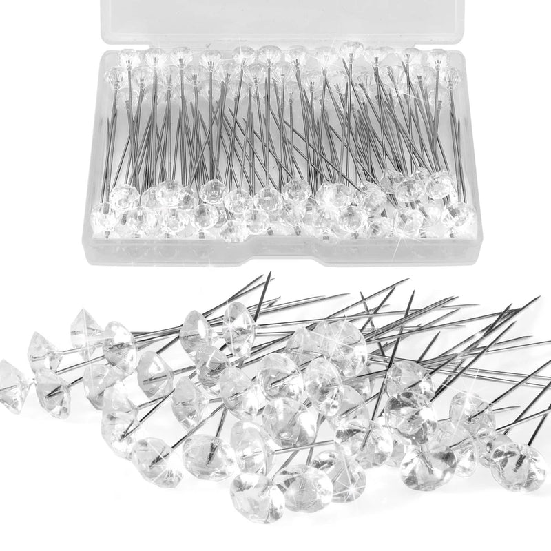 Clear rhinestone flower pins with metal needles, shown loose and in a plastic storage case