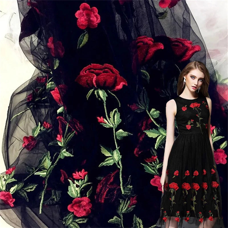 Sheer black tulle fabric with red rose floral embroidery and green leaves